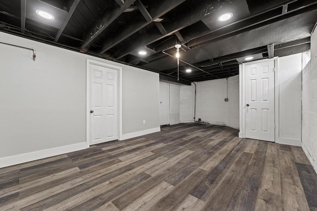 finished basement with dark wood-type flooring and baseboards