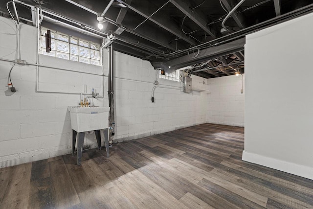 below grade area with electric panel and wood finished floors