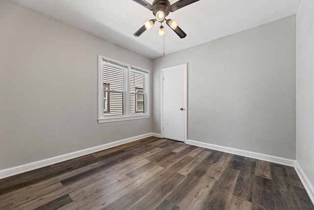 unfurnished room featuring baseboards, dark wood-style flooring, and ceiling fan