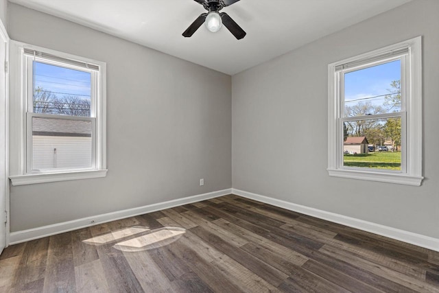 spare room featuring baseboards, dark wood-style flooring, and a ceiling fan