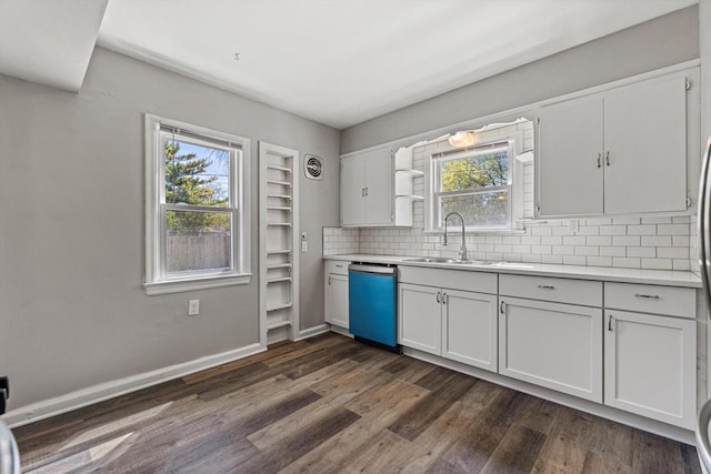 kitchen featuring a sink, dishwashing machine, dark wood-style flooring, backsplash, and light countertops