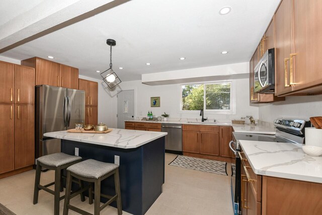 7113 N Navajo Ave, Glendale, WI 53217 - kitchen with stainless steel appliances, a sink, brown cabinetry, light stone counters, and a kitchen island