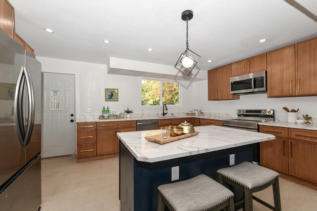 7113 N Navajo Ave, Glendale, WI 53217 - kitchen featuring stainless steel appliances, brown cabinets, a kitchen bar, recessed lighting, and a kitchen island