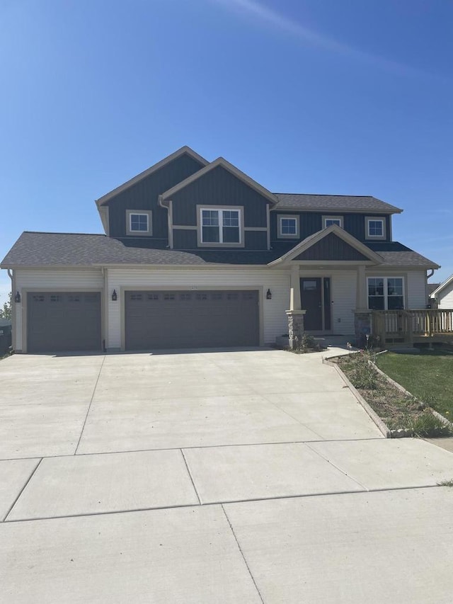 425 Champlain Dr, Johnson Creek, WI 53038 - view of front facade with driveway, board and batten siding, a garage, and an attached garage