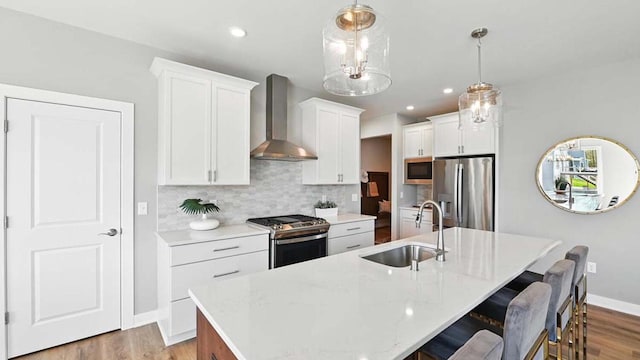 1117 5th Ave Unit Lt38, Union Grove, WI 53182 - kitchen featuring appliances with stainless steel finishes, wall chimney exhaust hood, a sink, a kitchen island with sink, and backsplash