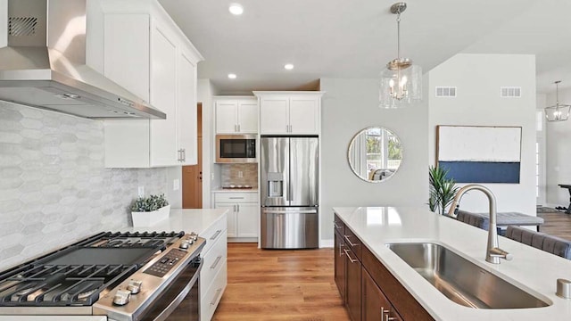 1117 5th Ave Unit Lt38, Union Grove, WI 53182 - kitchen with appliances with stainless steel finishes, a sink, wall chimney range hood, light countertops, and light wood finished floors