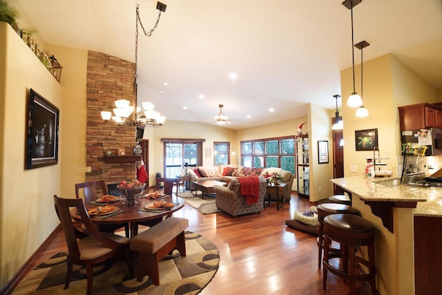 1839 Trevino Trl Unit 6, Mount Pleasant, WI 53405 - dining room with wood finished floors, high vaulted ceiling, a fireplace, and a chandelier