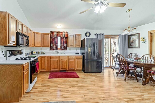 1809 S Badger Ct, Arkdale, WI 54613 - kitchen featuring freestanding refrigerator, range with gas stovetop, black microwave, lofted ceiling, and a sink