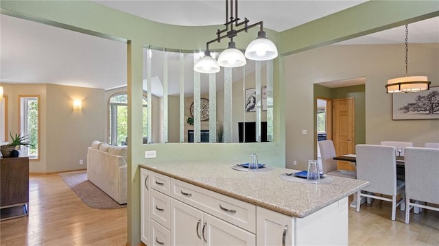 2649 W Menomonie St, Eau Claire, WI 54703 - kitchen with light wood-style floors, white cabinets, and hanging light fixtures