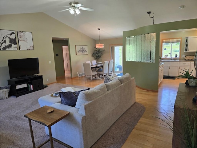 2649 W Menomonie St, Eau Claire, WI 54703 - living room featuring plenty of natural light, a ceiling fan, vaulted ceiling, light wood-style floors, and baseboards