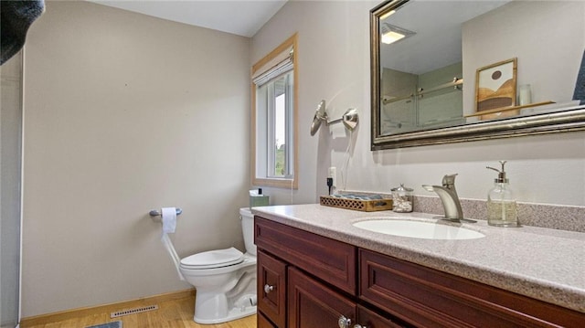 2649 W Menomonie St, Eau Claire, WI 54703 - full bathroom with an enclosed shower, toilet, wood finished floors, vanity, and baseboards