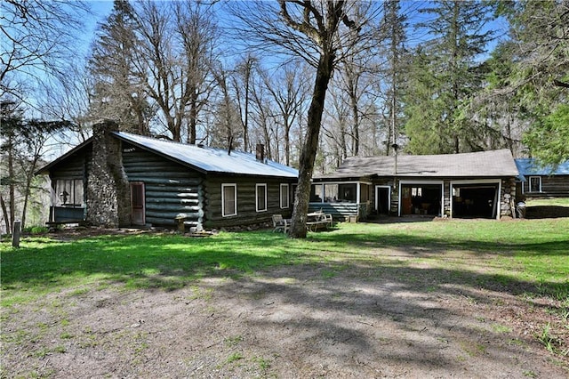 6070 Payne Farm Rd, Winter, WI 54896 - rear view of house featuring a chimney, a garage, a lawn, driveway, and log siding