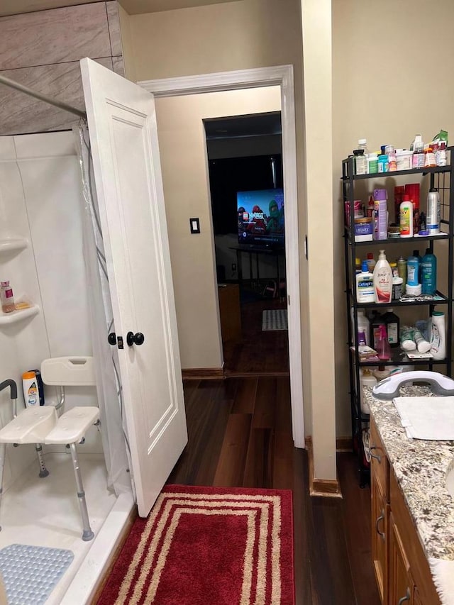 1728 W Capitol Dr, Milwaukee, WI 53206 - bathroom featuring wood finished floors, a shower, and baseboards