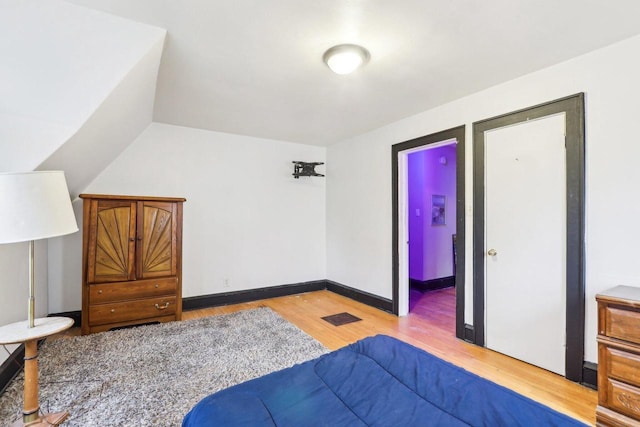 1728 W Capitol Dr, Milwaukee, WI 53206 - bedroom with light wood-style floors, lofted ceiling, and baseboards