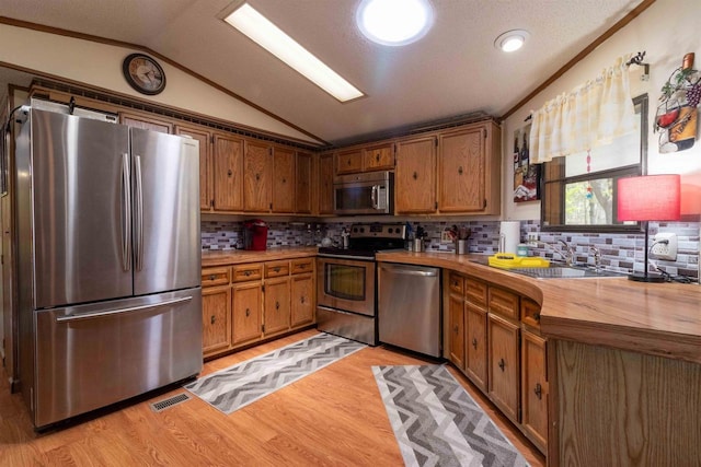 1870 County Road F Unit L69, Friendship, WI 53934 - kitchen with stainless steel appliances, lofted ceiling, light wood-style floors, tasteful backsplash, and a sink