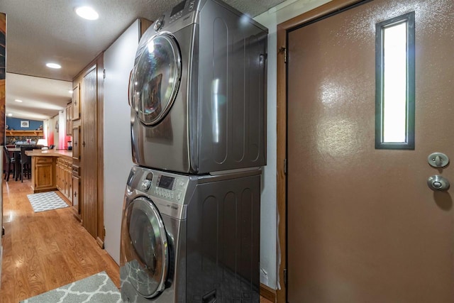 1870 County Road F Unit L69, Friendship, WI 53934 - clothes washing area with stacked washing machine and dryer, light wood-style flooring, recessed lighting, and a textured ceiling