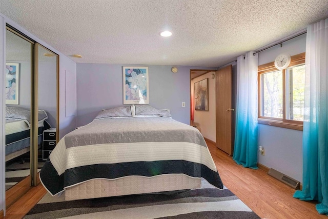 1870 County Road F Unit L69, Friendship, WI 53934 - bedroom with light wood-style flooring, a textured ceiling, a closet, recessed lighting, and baseboards
