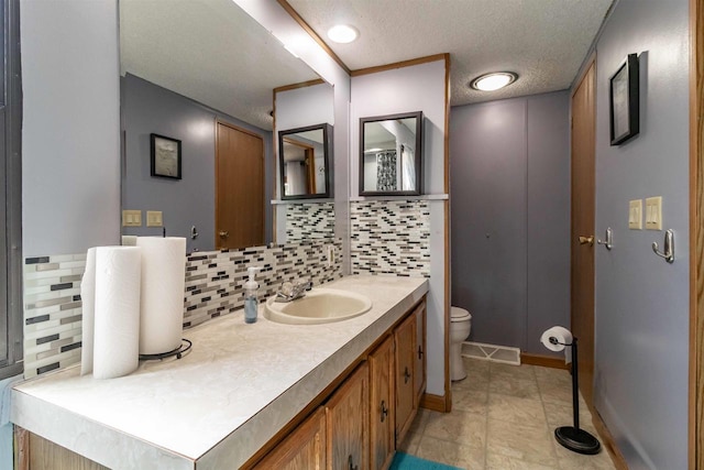 1870 County Road F Unit L69, Friendship, WI 53934 - bathroom featuring backsplash, toilet, vanity, a textured ceiling, and baseboards