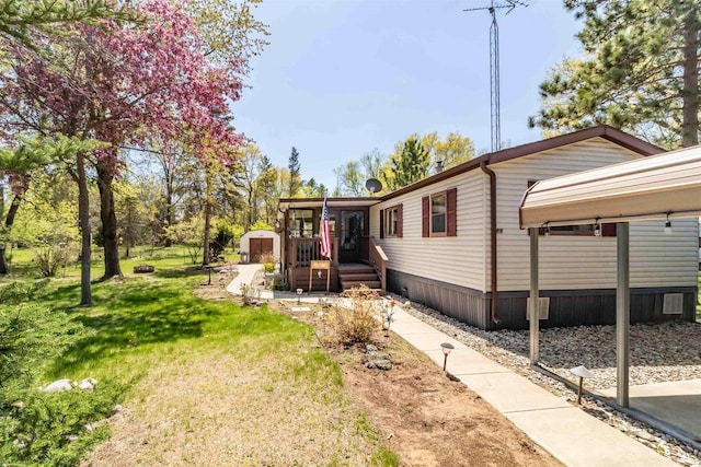 1870 County Road F Unit L69, Friendship, WI 53934 - view of side of home featuring a shed, a lawn, and an outbuilding
