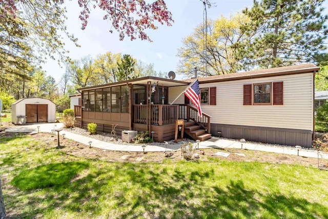 1870 County Road F Unit L69, Friendship, WI 53934 - back of property with a sunroom, an outdoor structure, a lawn, and a storage shed