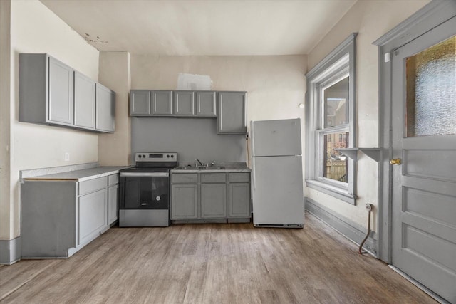 1341 S Layton Blvd Unit 1343, Milwaukee, WI 53215 - kitchen featuring freestanding refrigerator, stainless steel range with electric cooktop, gray cabinetry, and light wood-style flooring