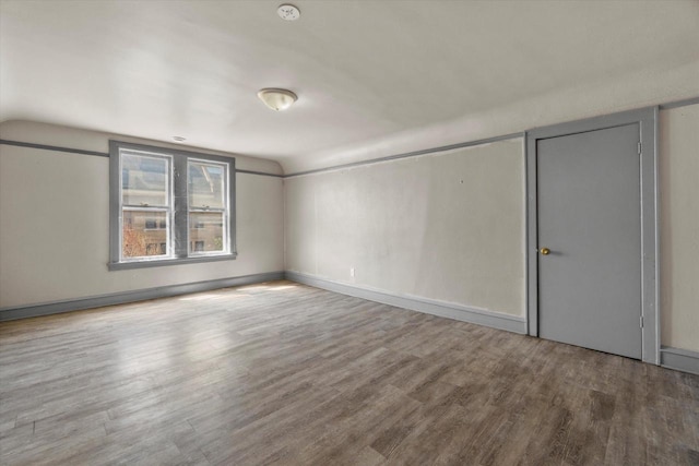 1341 S Layton Blvd Unit 1343, Milwaukee, WI 53215 - spare room featuring wood finished floors, vaulted ceiling, and baseboards