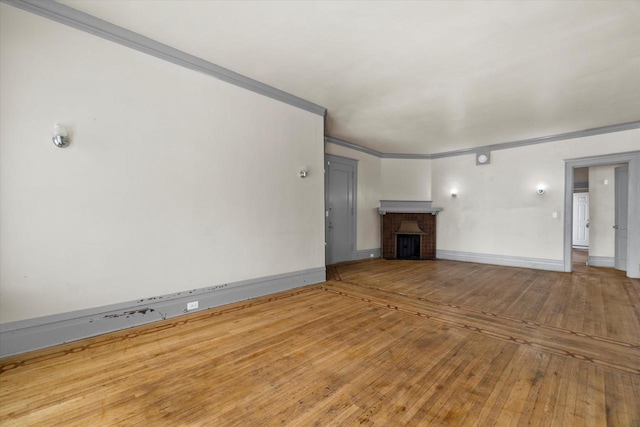 1341 S Layton Blvd Unit 1343, Milwaukee, WI 53215 - unfurnished living room featuring hardwood / wood-style flooring, a brick fireplace, ornamental molding, and baseboards