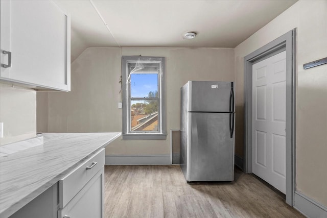 1341 S Layton Blvd Unit 1343, Milwaukee, WI 53215 - kitchen with freestanding refrigerator, light wood finished floors, white cabinets, baseboards, and lofted ceiling