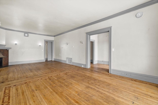 1341 S Layton Blvd Unit 1343, Milwaukee, WI 53215 - unfurnished living room featuring ornamental molding, a brick fireplace, hardwood / wood-style flooring, and baseboards