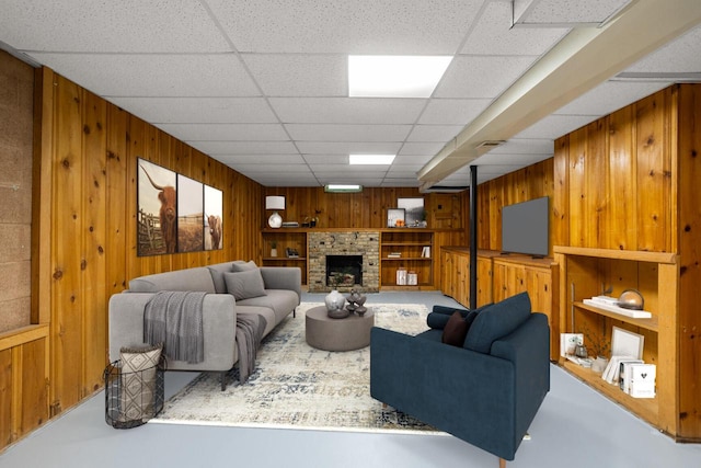 N56W27528 Lisbon Rd, Lisbon, WI 53089 - living room featuring wood walls, a drop ceiling, a fireplace, and finished concrete flooring
