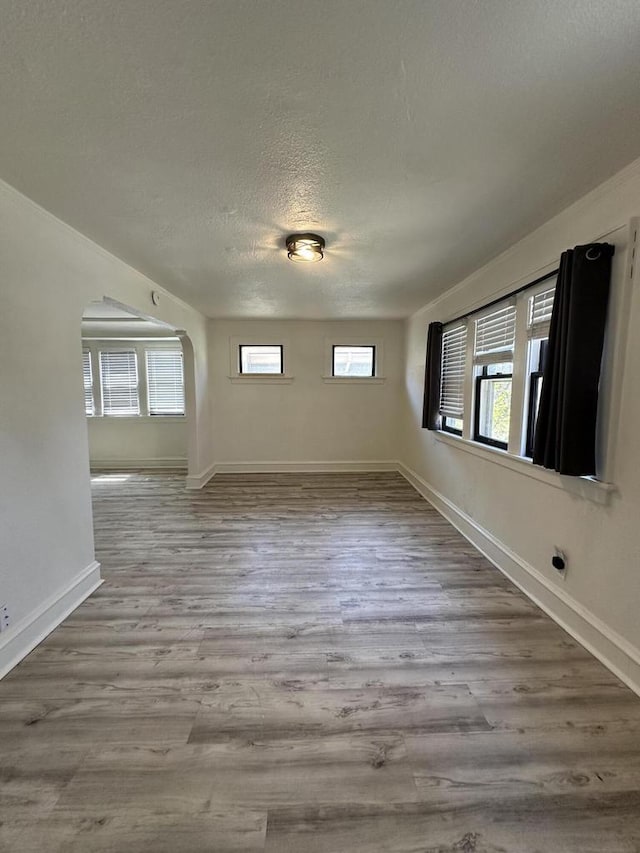 3158 N 39th St Unit 3160, Milwaukee, WI 53216 - unfurnished dining area featuring a textured ceiling, wood finished floors, baseboards, and arched walkways