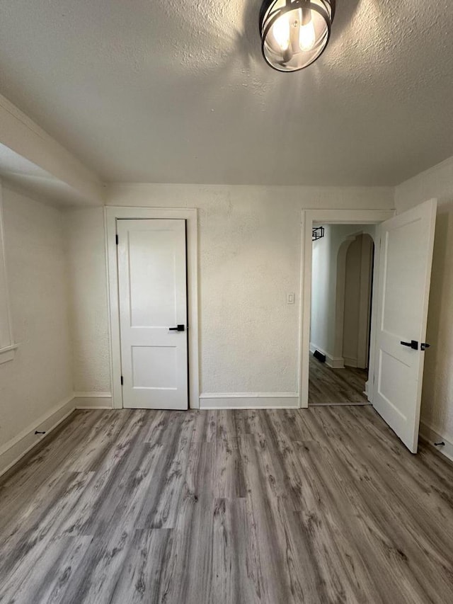 3158 N 39th St Unit 3160, Milwaukee, WI 53216 - unfurnished room with a textured ceiling, wood finished floors, arched walkways, and baseboards