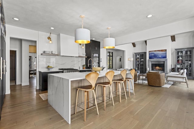 536 Sunrise Bay Rd, Neenah, WI 54956 - kitchen with a spacious island, light wood-type flooring, a breakfast bar area, backsplash, and recessed lighting