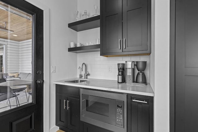 536 Sunrise Bay Rd, Neenah, WI 54956 - kitchen with a sink, open shelves, stainless steel microwave, decorative backsplash, and light countertops