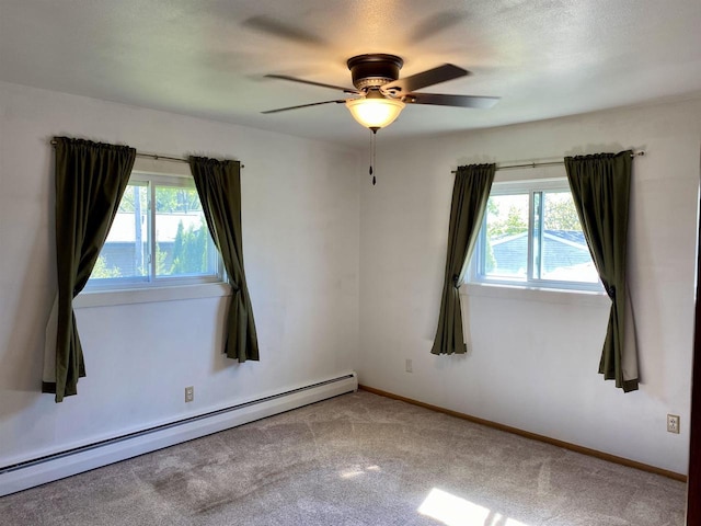 spare room featuring a baseboard radiator, a ceiling fan, carpet floors, and baseboards