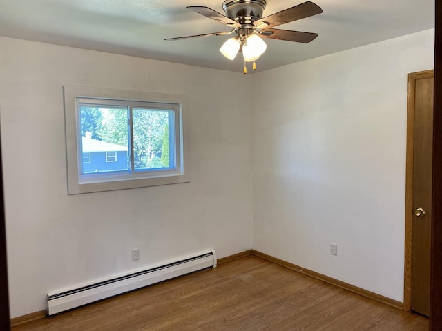 spare room with a baseboard heating unit, light wood-style floors, baseboards, and a ceiling fan