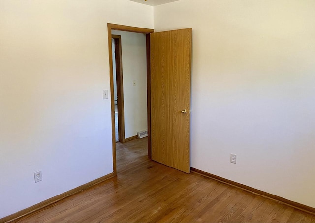 empty room featuring wood finished floors and baseboards
