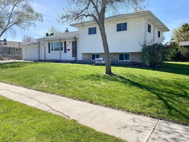 tri-level home with an attached garage and a front lawn