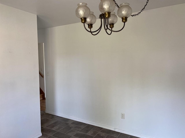 unfurnished dining area featuring a chandelier and baseboards