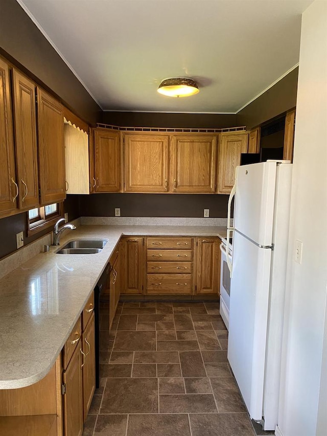 kitchen featuring white appliances, a sink, stone finish floors, and brown cabinetry