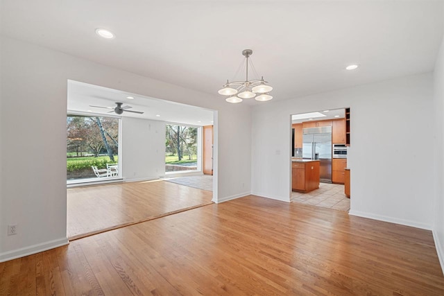7515 N Beach Dr, Fox Point, WI 53217 - unfurnished living room with light wood-style floors, a chandelier, baseboards, and recessed lighting