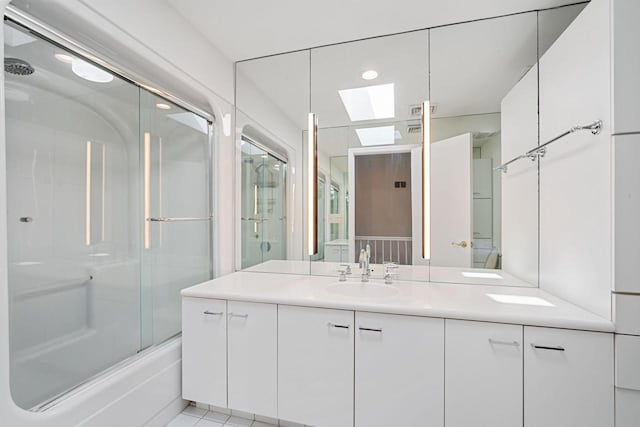 7515 N Beach Dr, Fox Point, WI 53217 - full bathroom featuring a skylight, vanity, combined bath / shower with glass door, and tile patterned floors