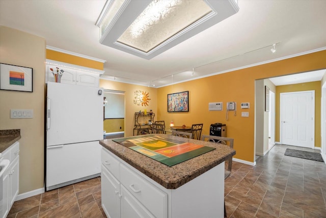 1401 Scenic Dr, Hubertus, WI 53033 - kitchen with freestanding refrigerator, rail lighting, a center island, ornamental molding, and white cabinets
