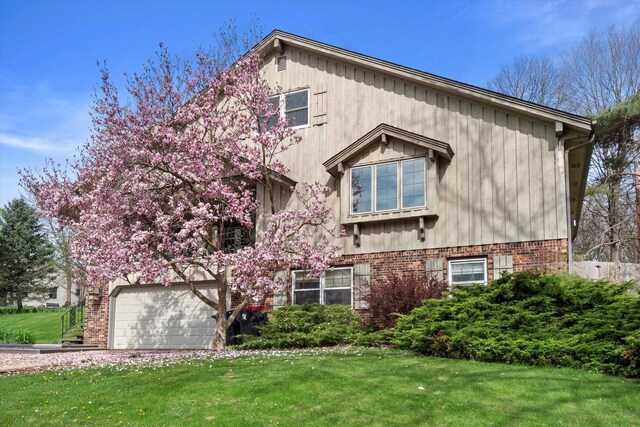 1401 Scenic Dr, Hubertus, WI 53033 - view of front of home featuring an attached garage and a front lawn