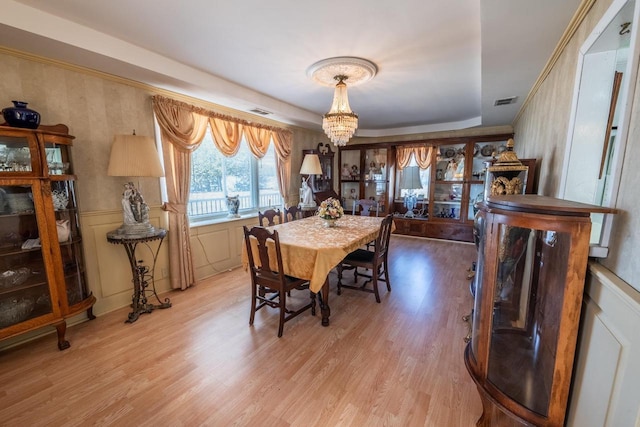 1226 Lake St, White Lake, WI 54491 - dining space featuring a chandelier, wood finished floors, a tray ceiling, and wainscoting