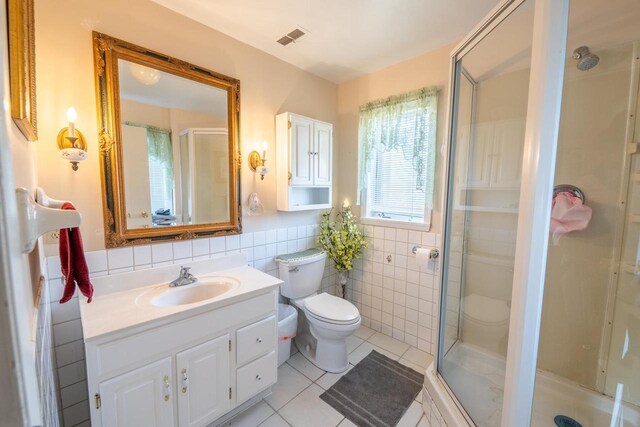 1226 Lake St, White Lake, WI 54491 - bathroom featuring tile walls, a stall shower, tile patterned floors, toilet, and vanity
