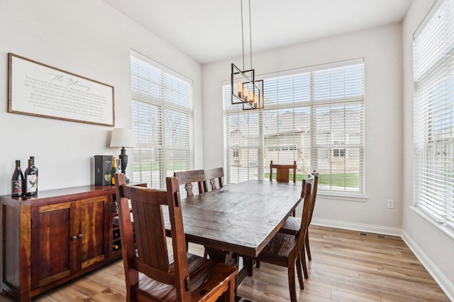 W139S9977 Jay Dr, Muskego, WI 53150 - dining room with a chandelier, light wood finished floors, and baseboards