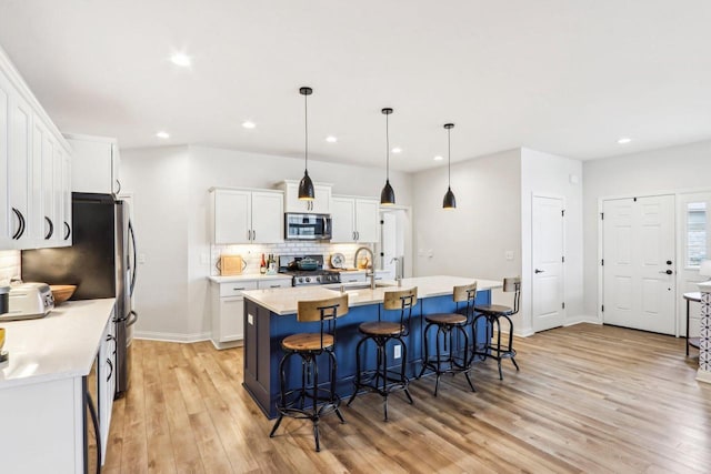 W139S9977 Jay Dr, Muskego, WI 53150 - kitchen featuring stainless steel appliances, a sink, tasteful backsplash, light wood-style floors, and white cabinets