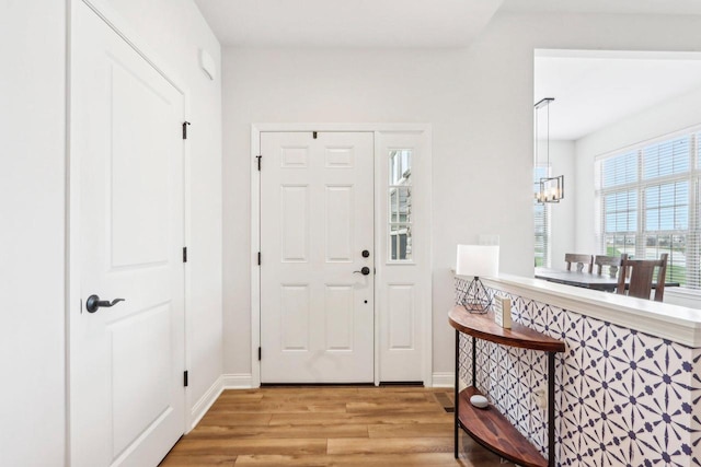 W139S9977 Jay Dr, Muskego, WI 53150 - foyer entrance featuring light wood-type flooring, a chandelier, and baseboards