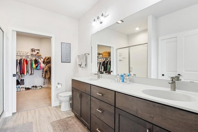 W139S9977 Jay Dr, Muskego, WI 53150 - full bathroom with wood finished floors, a stall shower, double vanity, and toilet